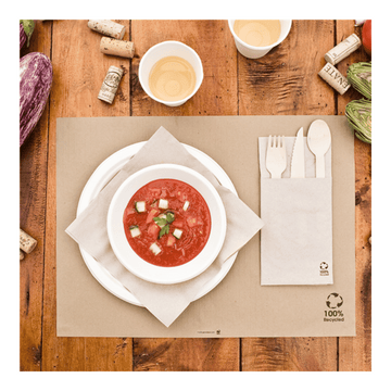 Tavola apparecchiata con tovaglietta, piatti  e posate e altri elementi da cucina